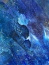 Dynamic and vibrant abstract painting with rich blue hues, showcasing fluid acrylic textures and artistic expression.